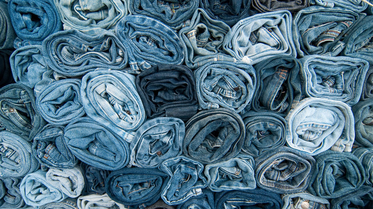 A photo of various shades of rolled up denim jeans